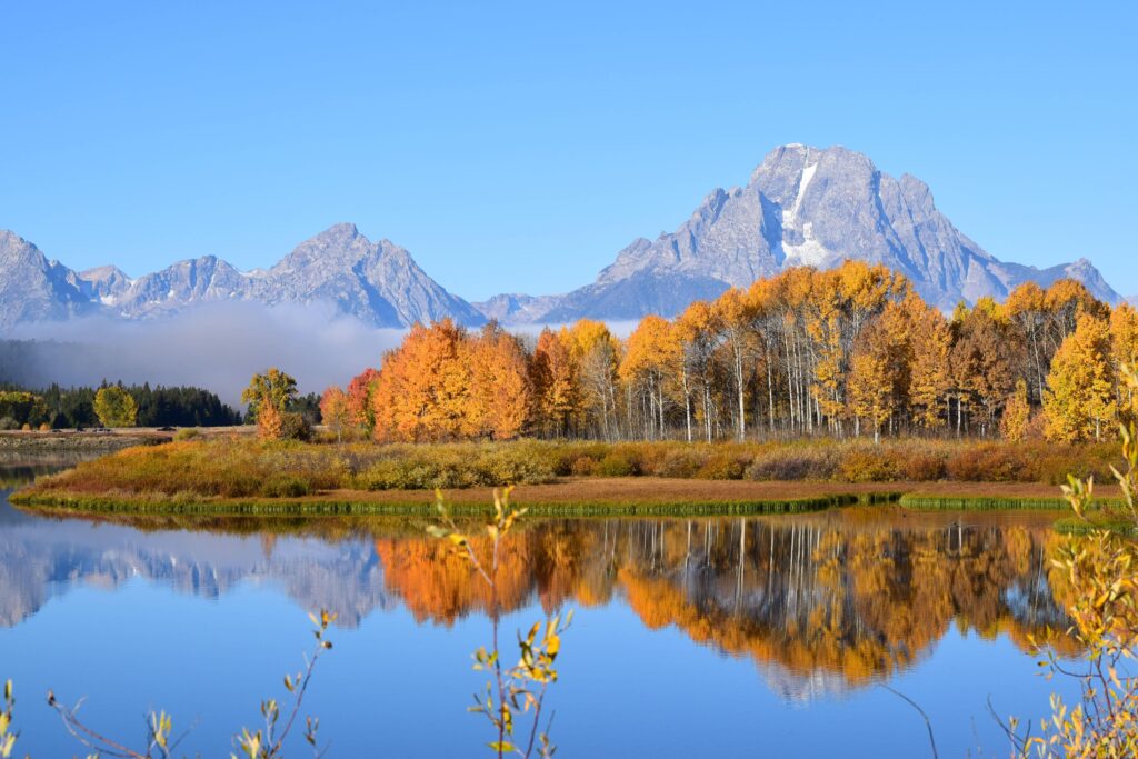 Breathtaking autumn scene of Grand Teton reflecting in a serene lake in Wyoming, USA