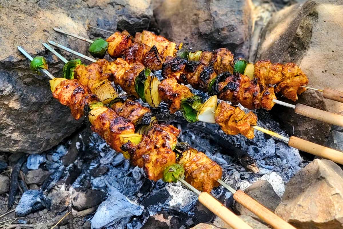 24 Make Ahead Camping Meals - Chicken Skewers on open flames