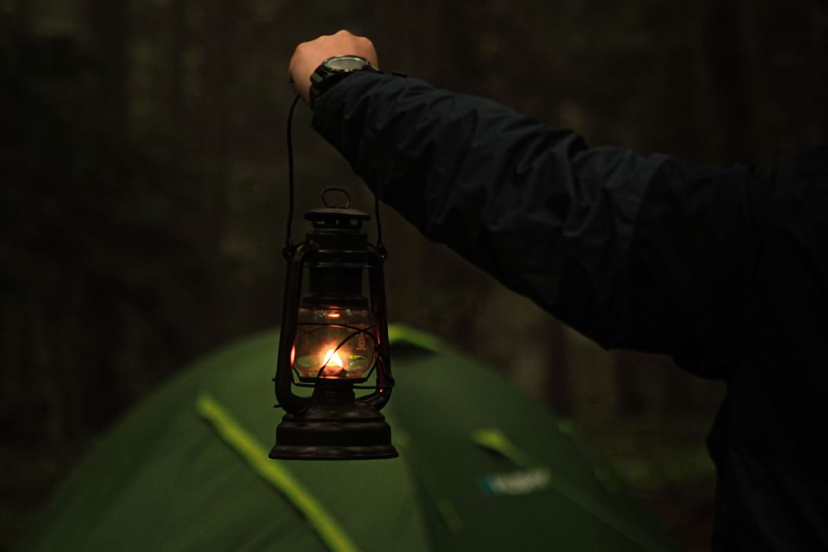 Holding up a lantern while camping